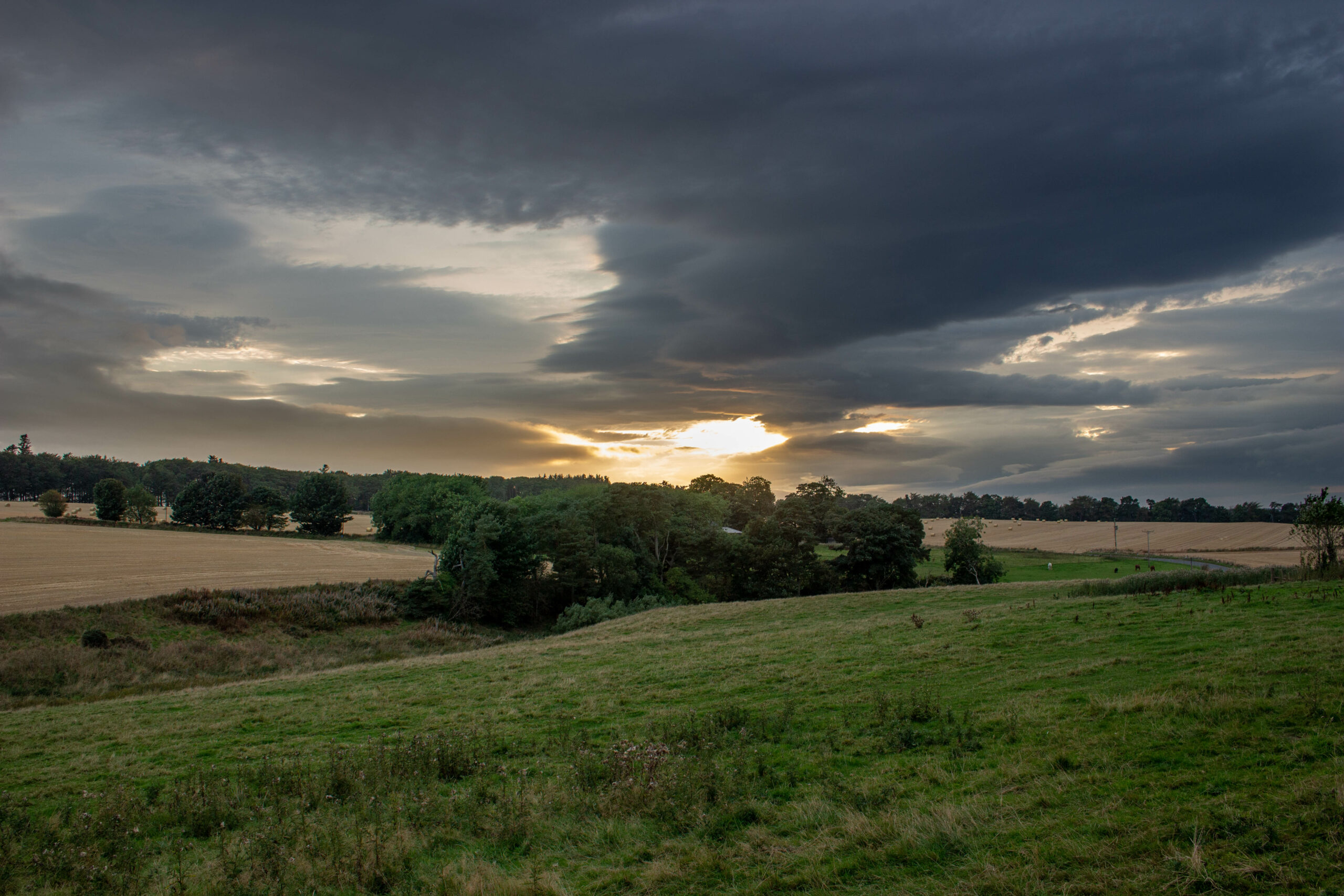 Sunset with Dark clouds over farm land